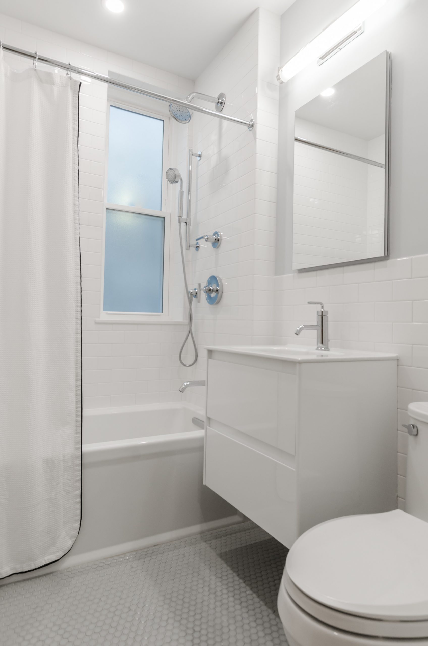 A plain white bathroom with vinyl floor